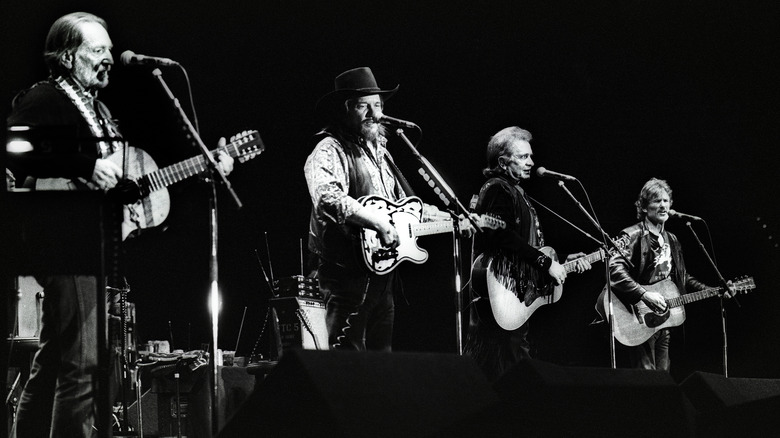 Willie Nelson, Waylon Jennings, Johnny Cash, and Kris Kristofferson performing together on stage as The Highwaymen