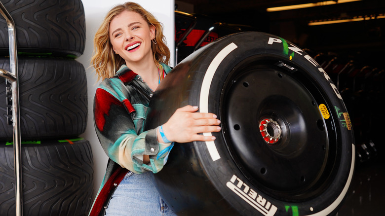 Chloe Grace Moretz holding a tire