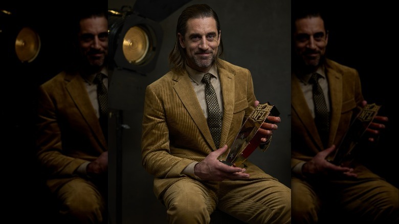 Aaron Rodgers posing with 2021 MVP award