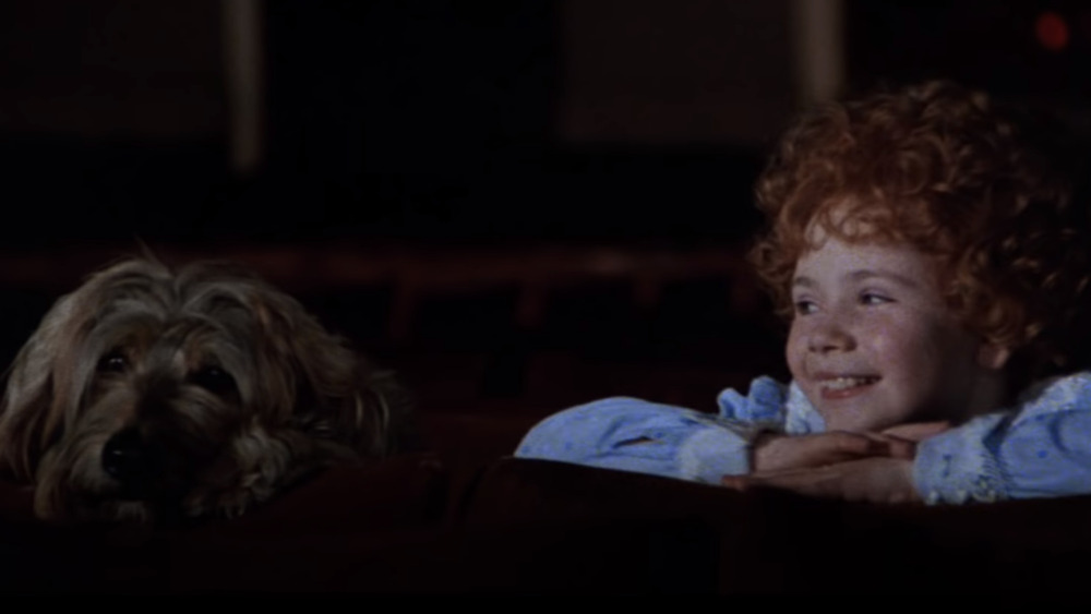 Aileen Quinn as Annie smiling at her dog