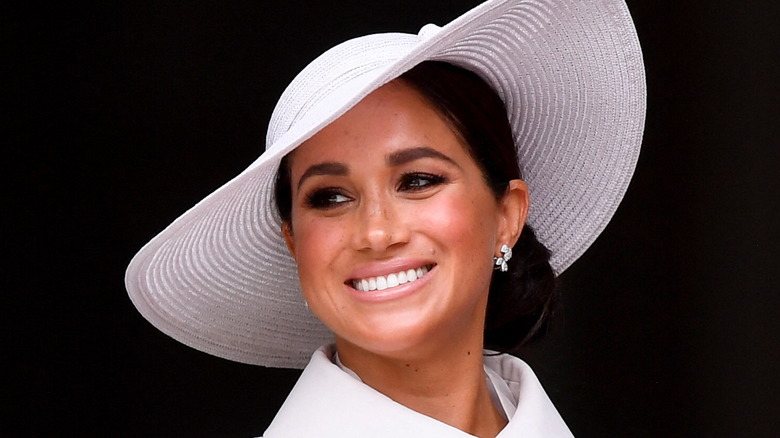 Meghan Markle smiles in a hat