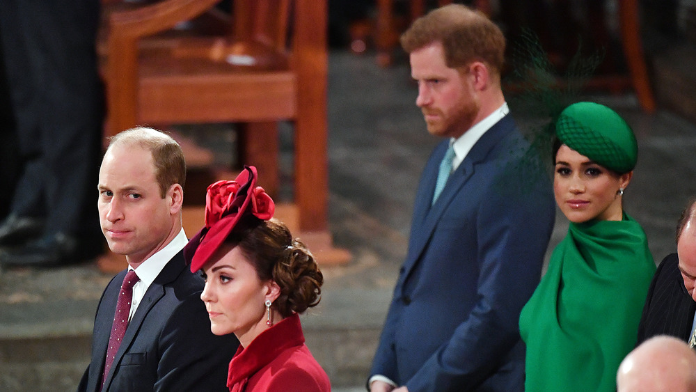 Prince William, Kate Middleton, Prince Harry, and Meghan Markle standing in separate rows at a service