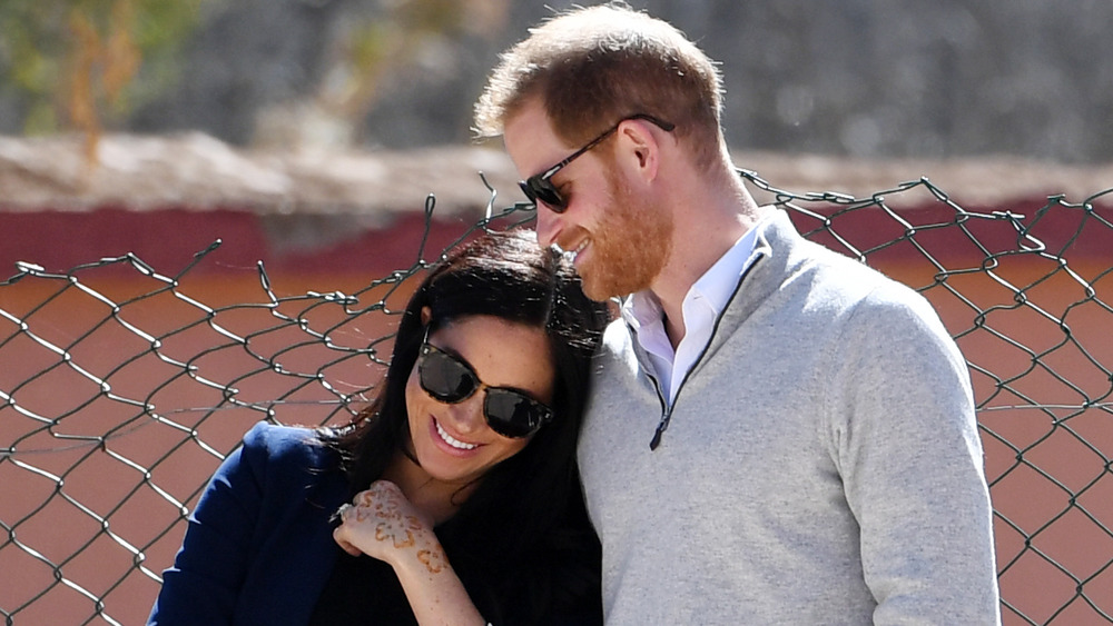 Meghan Markle and Prince Harry smiling arm-in-arm