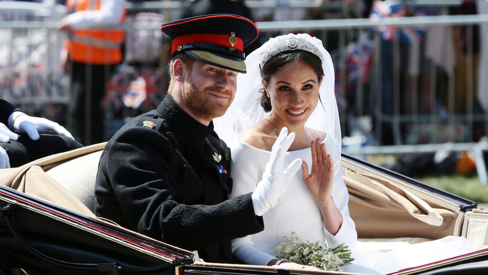 Prince Harry and Meghan Markle waving in a carriage