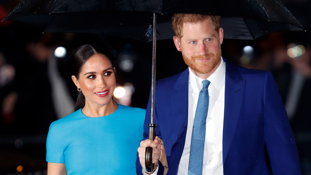 Meghan Markle and Prince Harry under an umbrella