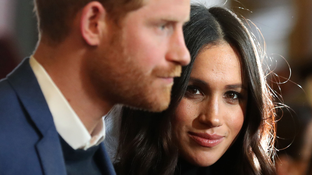 Prince Harry and Meghan Markle with neutral expressions