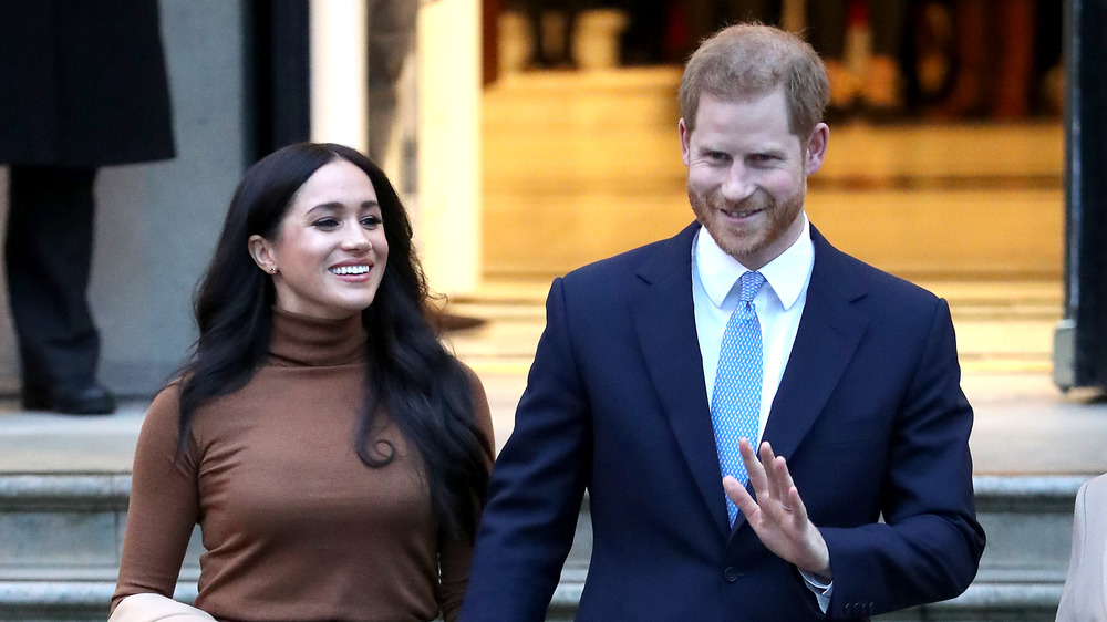 Meghan Markle and Prince Harry smiling and waving