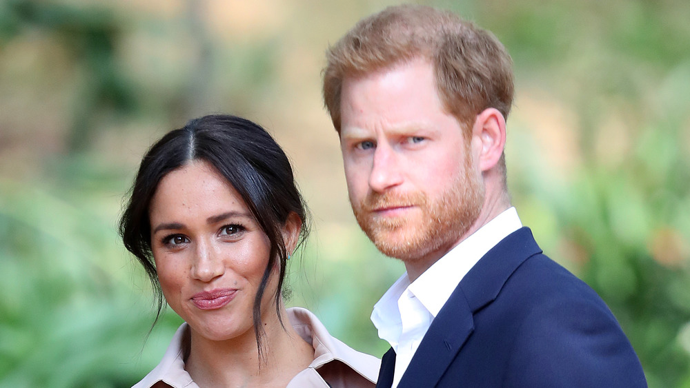 Meghan Markle and Prince Harry standing outside