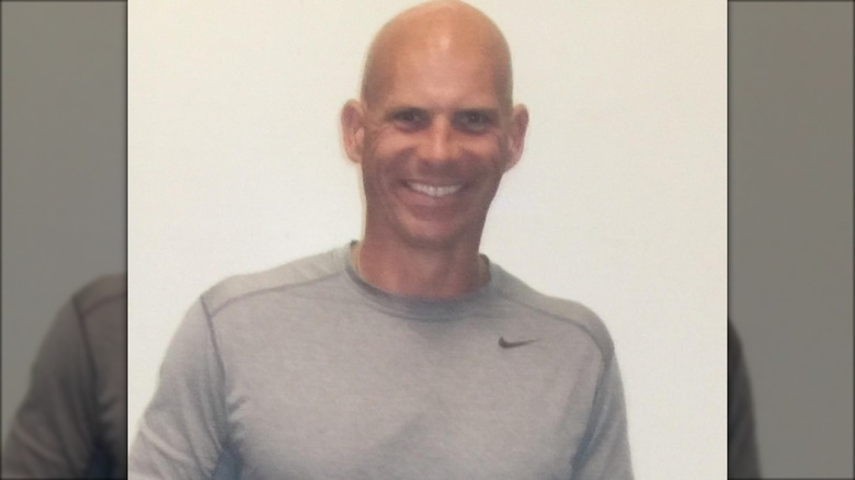 Lyle Menendez smiling wearing a gray shirt