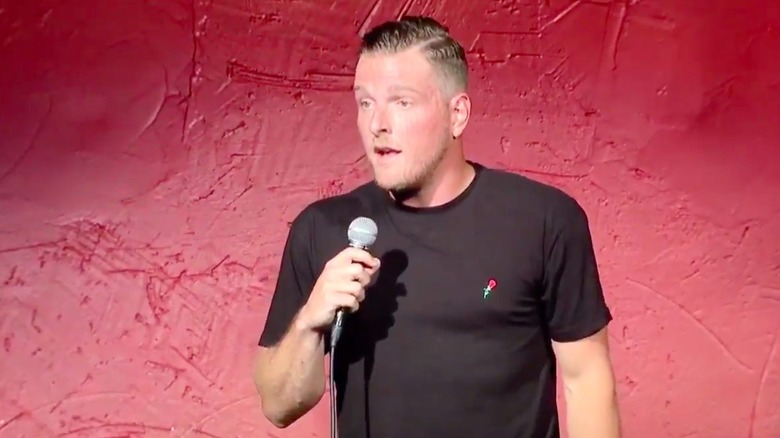 Pat McAfee performing standup at a comedy club