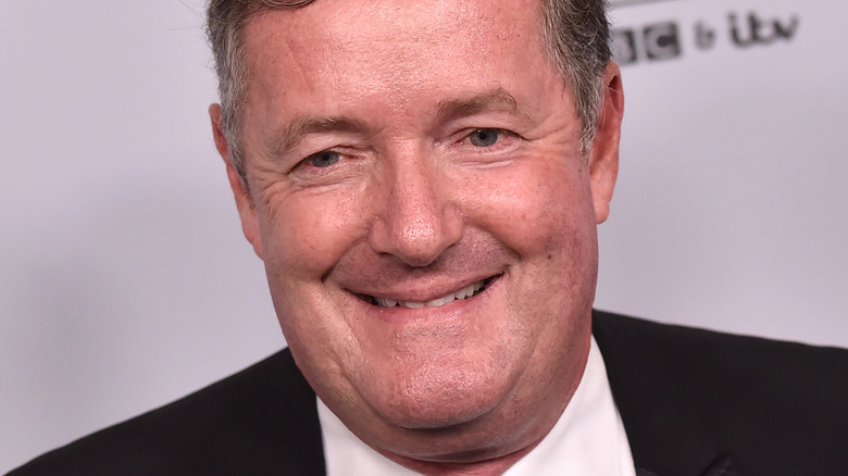 Piers Morgan double chin black suit