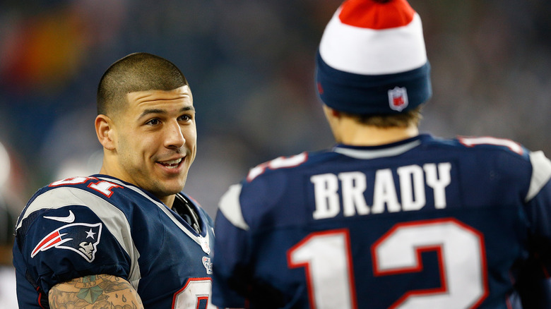 Aaron Hernandez talking to Tom Brady on the field 