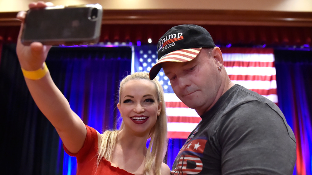 John Wayne Bobbitt poses with fan in Trump-supportive gear