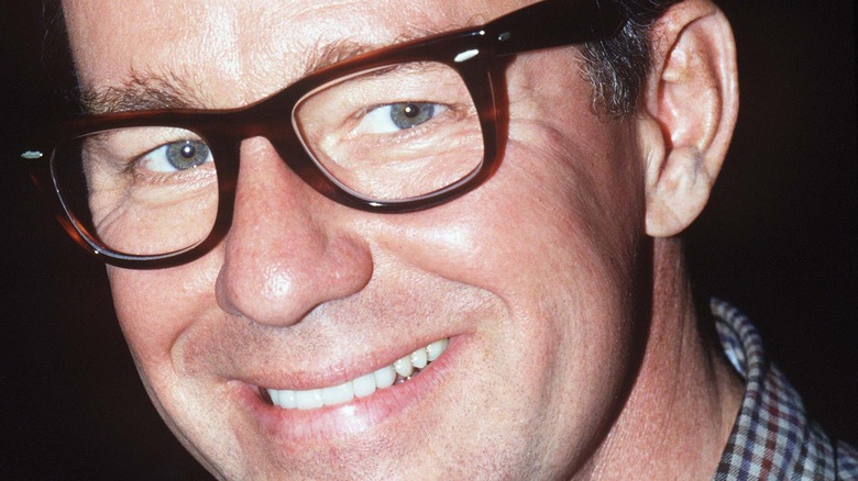 Phil Hartman smiling with glasses