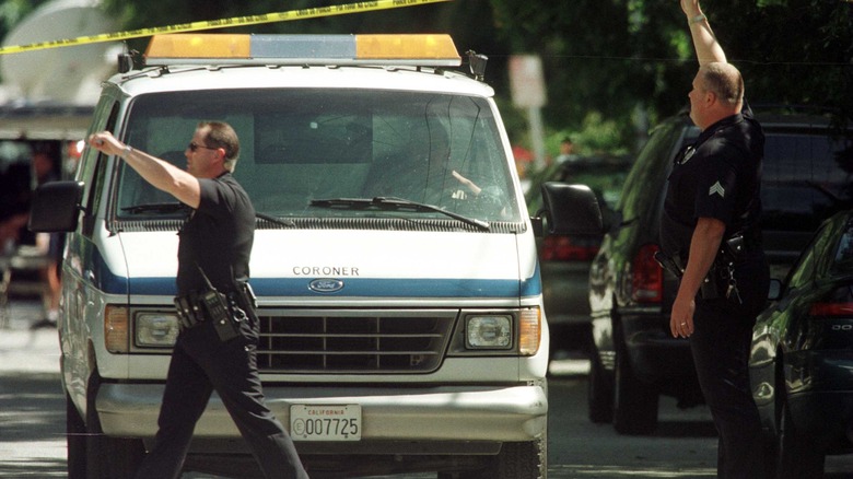 Police officers and coroner vehicle at scene of the crime