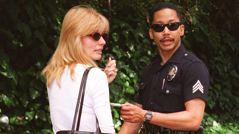 Andrea Diamond with police officer outside the Hartman home