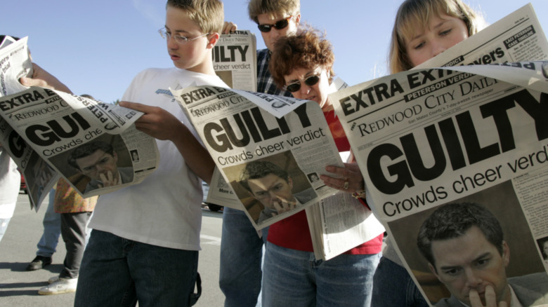 A crowd looking at newspapers featuring a headline about Scott Peterson's guilty verdict 