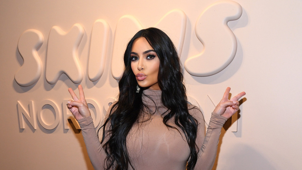 Kim Kardashian pouting while throwing up peace signs