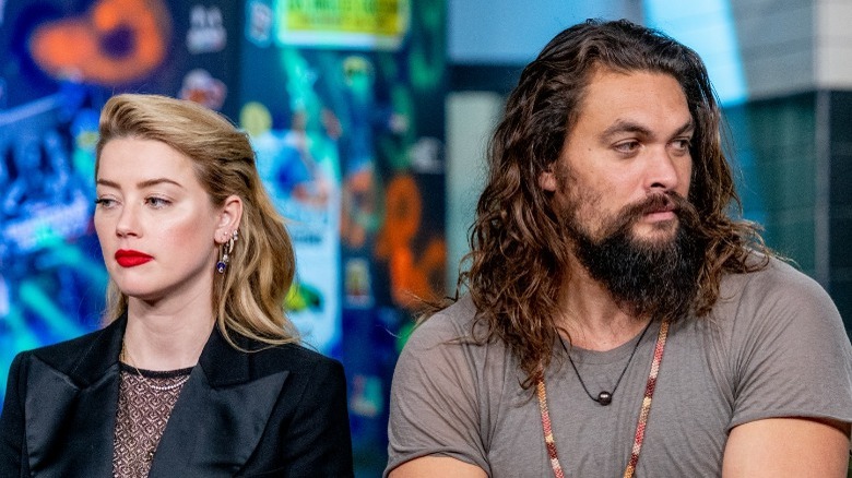 Amber Heard and Jason Momoa looking in opposite directions