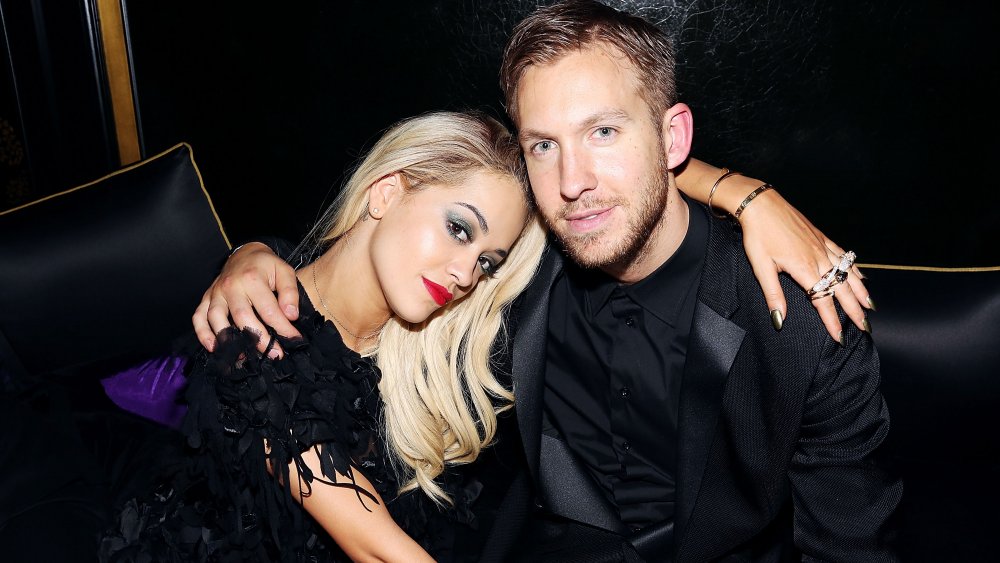 Rita Ora and Calvin Harris arm in arm, sitting down