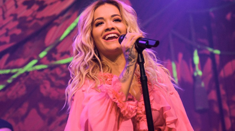 Rita Ora in pink outfit, performing on stage