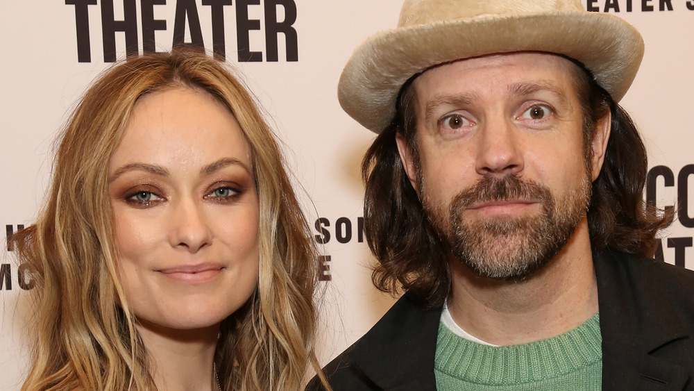 Olivia Wilde smiling next to Jason Sudeikis in a fuzz hat 