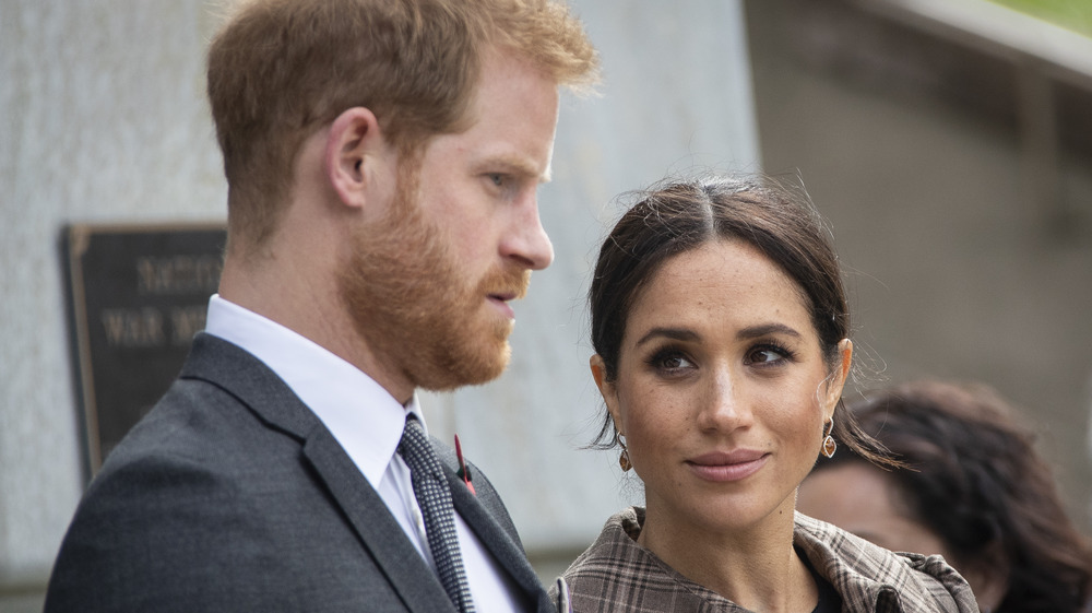 Prince Harry and Meghan Markle looking somber 