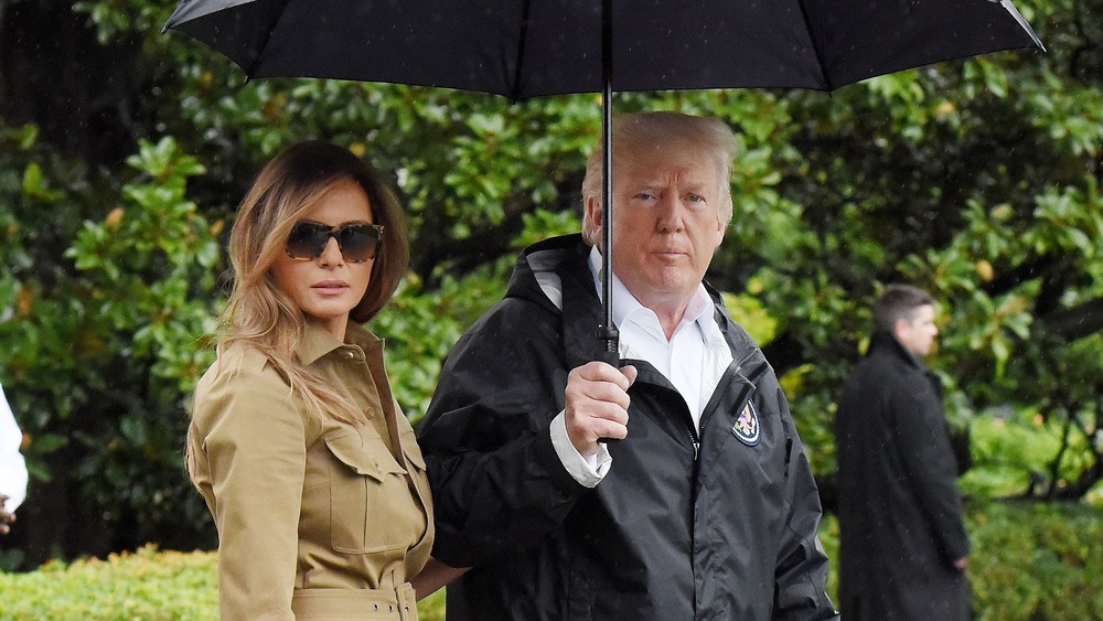 Melania and Donald Trump walking in the rain