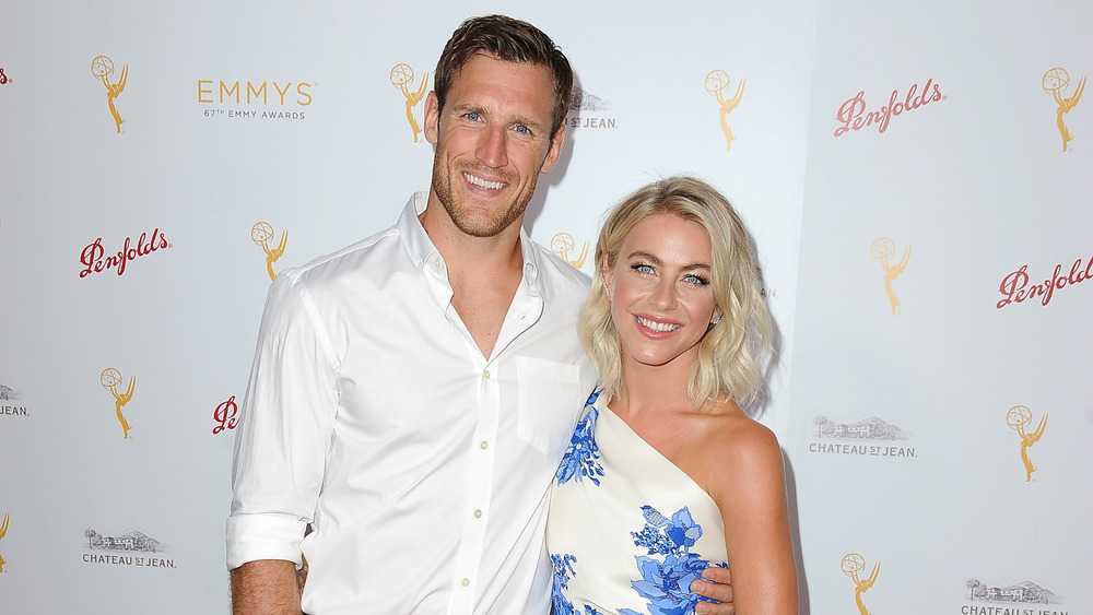 Brooks Laich and Julianne Hough smiling while posing arm in arm