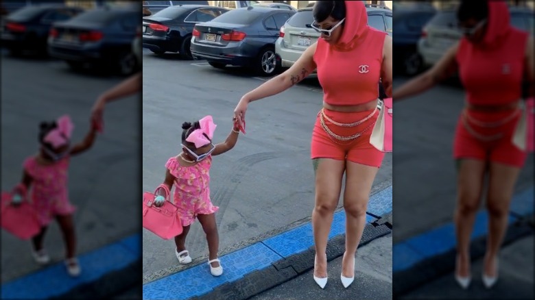 Cardi B and daughter Kulture Cephus walking on a street with matching Hermés Birkin bags.
