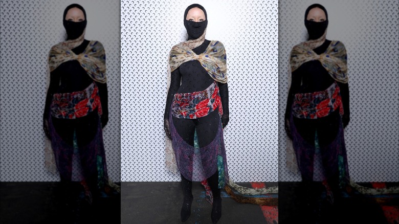 Noah Cyrus wearing a black catsuit covered with scarves at the Marine Serre Womenswear Fall/Winter 2024-2025 show