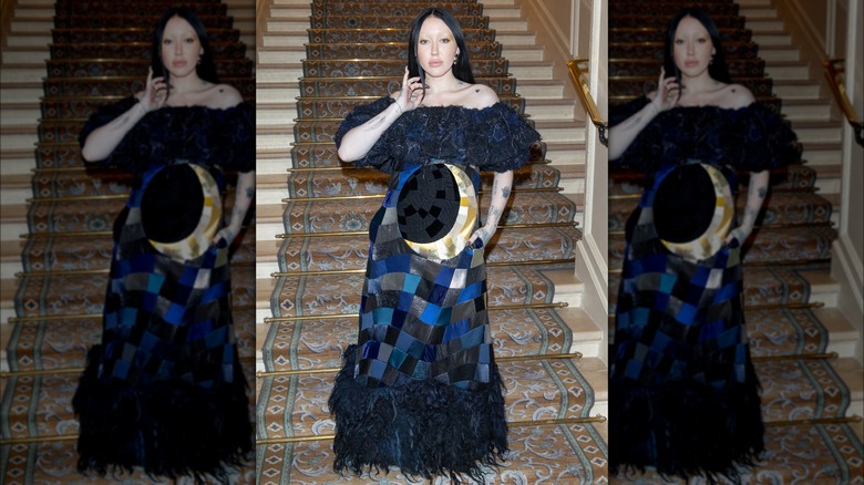 Noah Cyrus posing on stairs in a patchwork gown at the Viktor & Rolf Haute Couture Spring Summer 2023 show