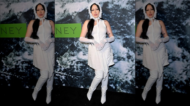 Noah Cyrus posing in a white outfit and bonnet at the 2023 Adidas x Stella McCartney launch event