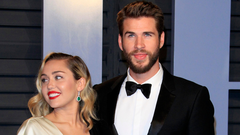 Miley Cyrus and Liam Hemsworth standing together