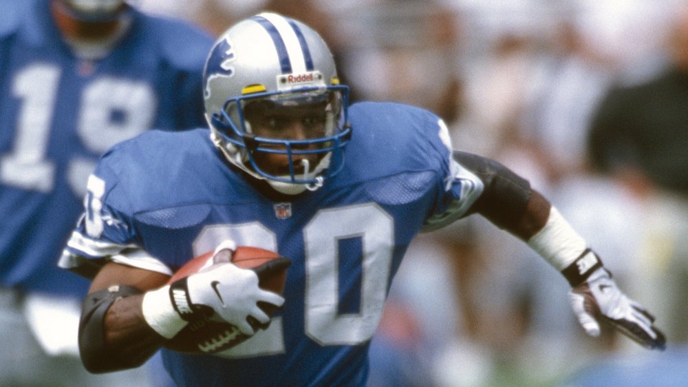 Barry Sanders running down the field, clutching a football