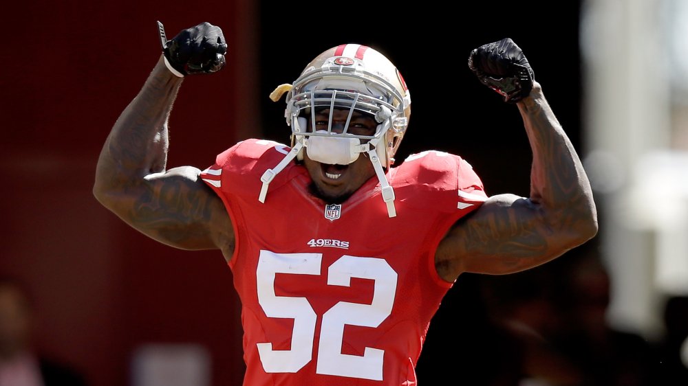 Patrick Willis yelling with his arms up while celebrating on the field