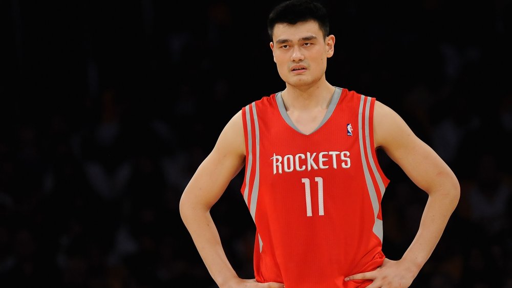 Yao Ming standing with his hands on his hips on the court