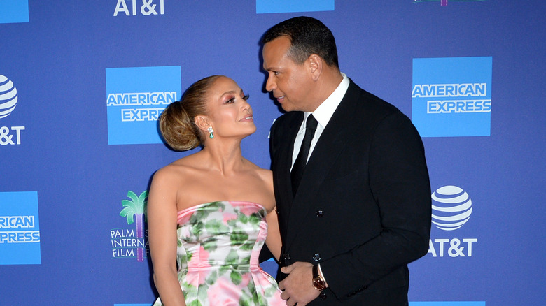 Jennifer Lopez wearing floral dress, Alex Rodriguez wearing black suit