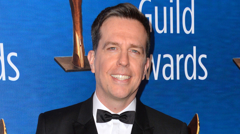 Ed Helms smiling on a red carpet