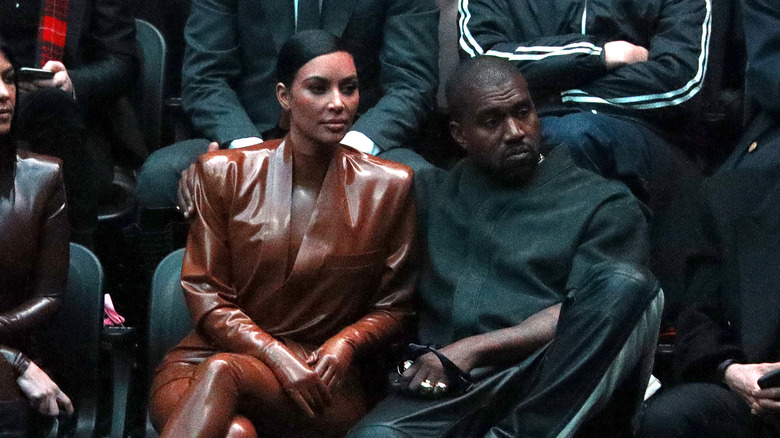 Kim Kardashian sitting with Kanye West 