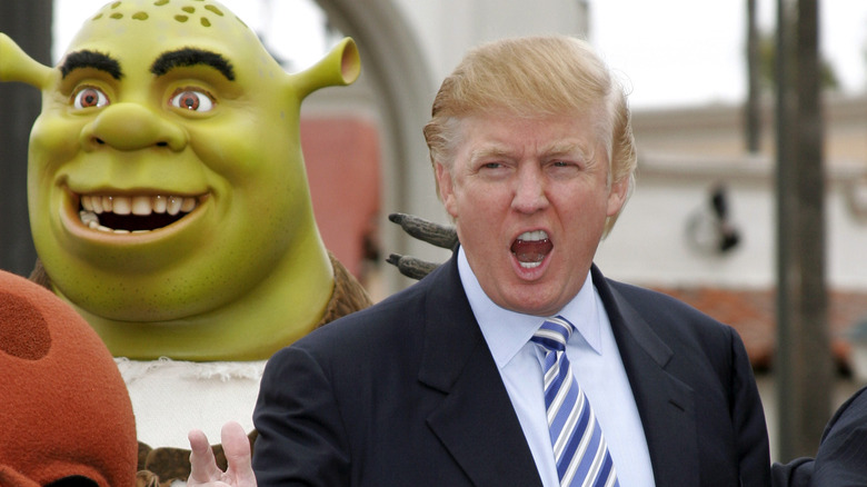 Donald Trump standing next to Shrek costume