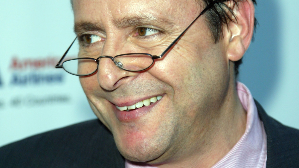 Judd Nelson smiling with glasses pushed down on his nose