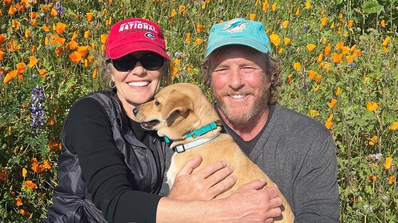 Susan Walters and Linden Ashby in a flower field 