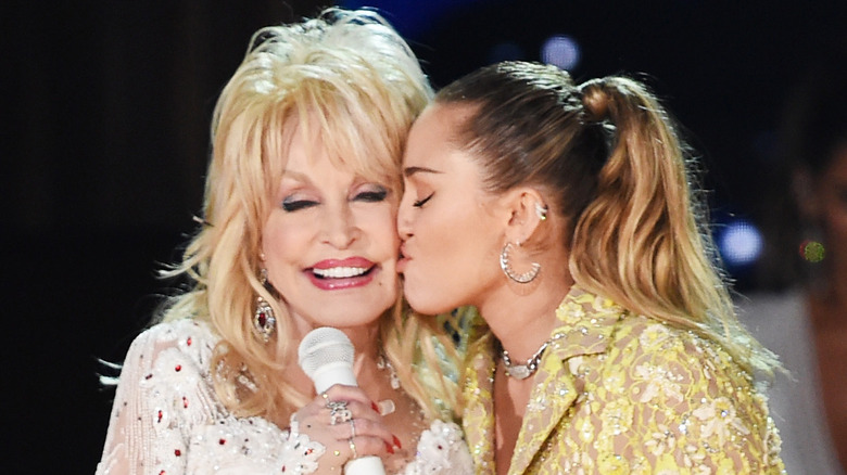 Miley Cyrus kissing Dolly Parton on the cheek