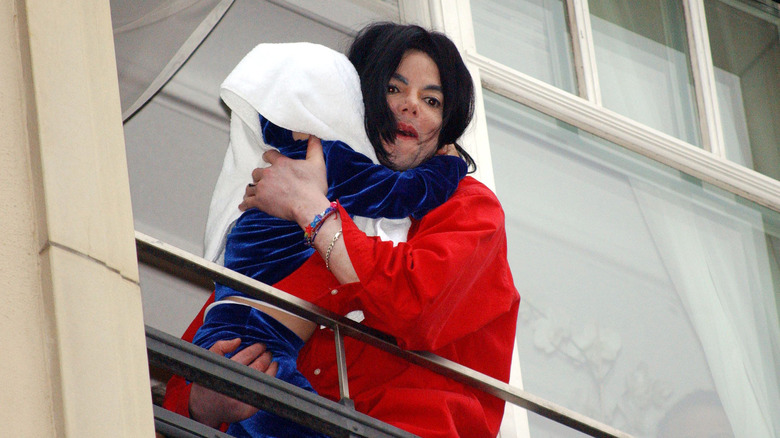 Michael Jackson holding his son out window