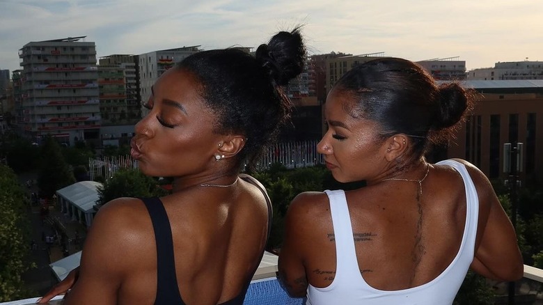 Biles and Chiles pose with backs turned