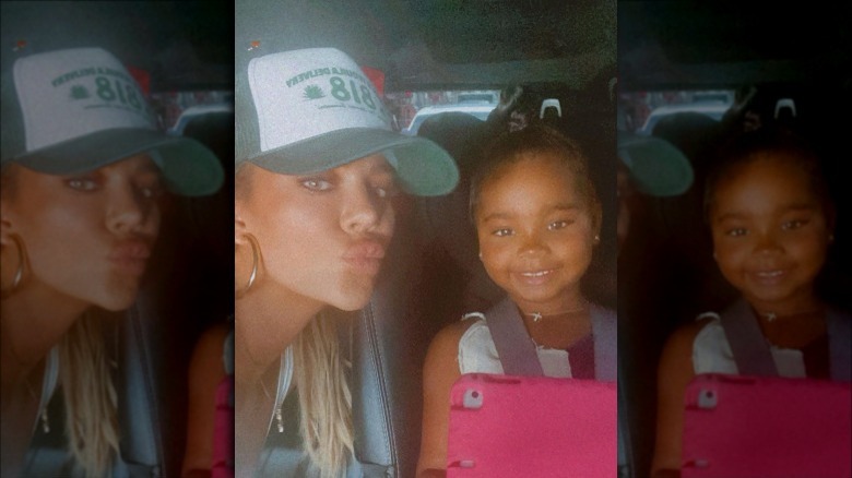 Khloe Kardashian poses with Trie in a car.