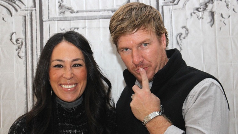 Joanna Gaines smiling, Chip Gaines with finger on lips