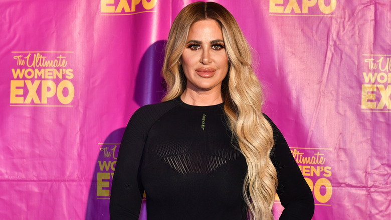 Kim Zolciak posing in black at The Ultimate Women's Expo