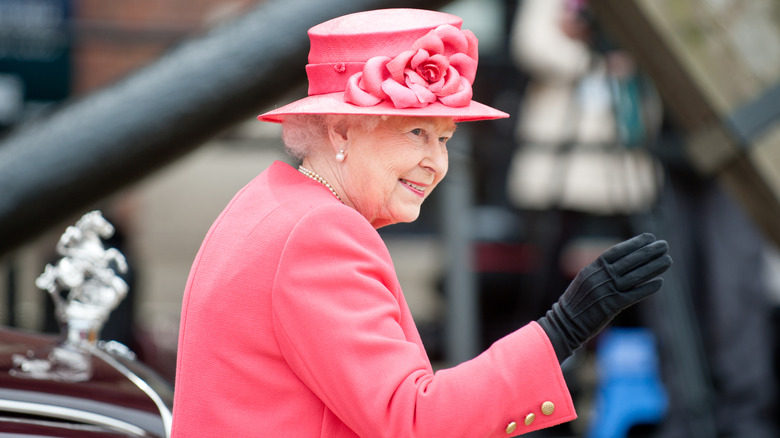 Queen Elizabeth wearing pink hat and waving